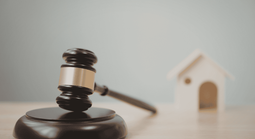 Martillo de subasta y casa de juguete, concepto de subastas inmobiliarias en línea.